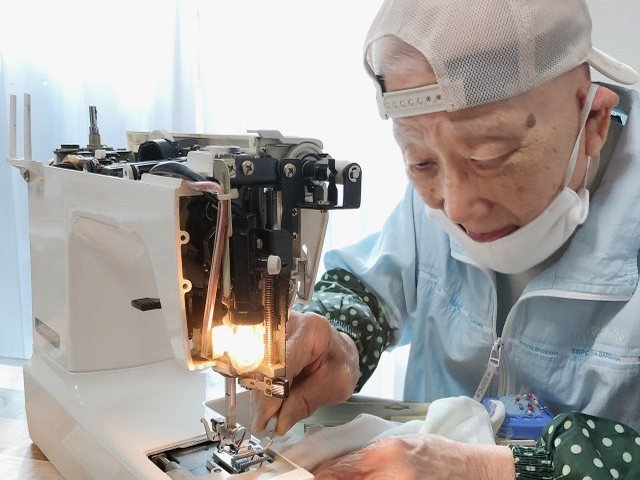 ミシンに向かって縫いものをするG3